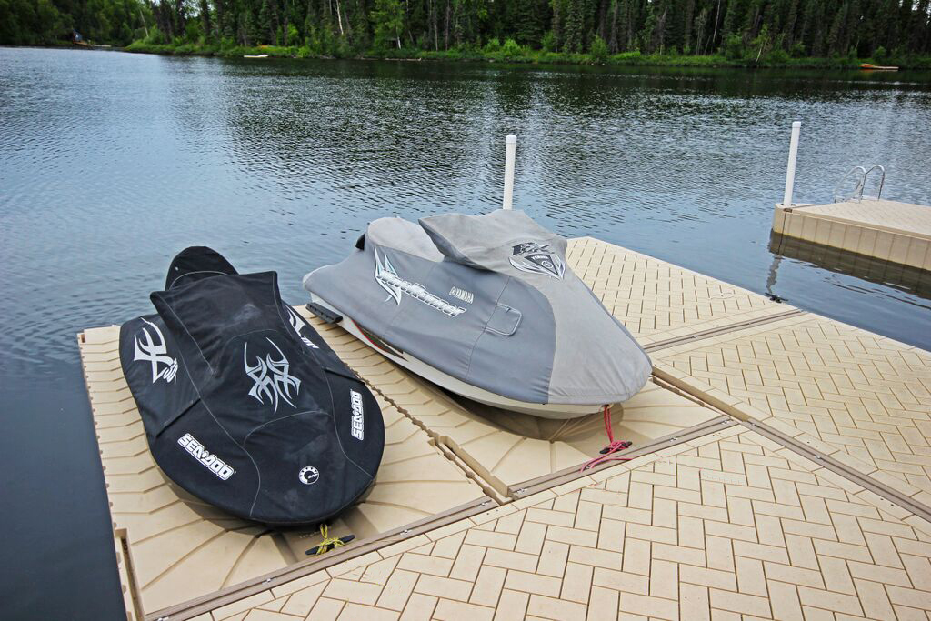Personal watercraft covered and secured on a floating lake dock