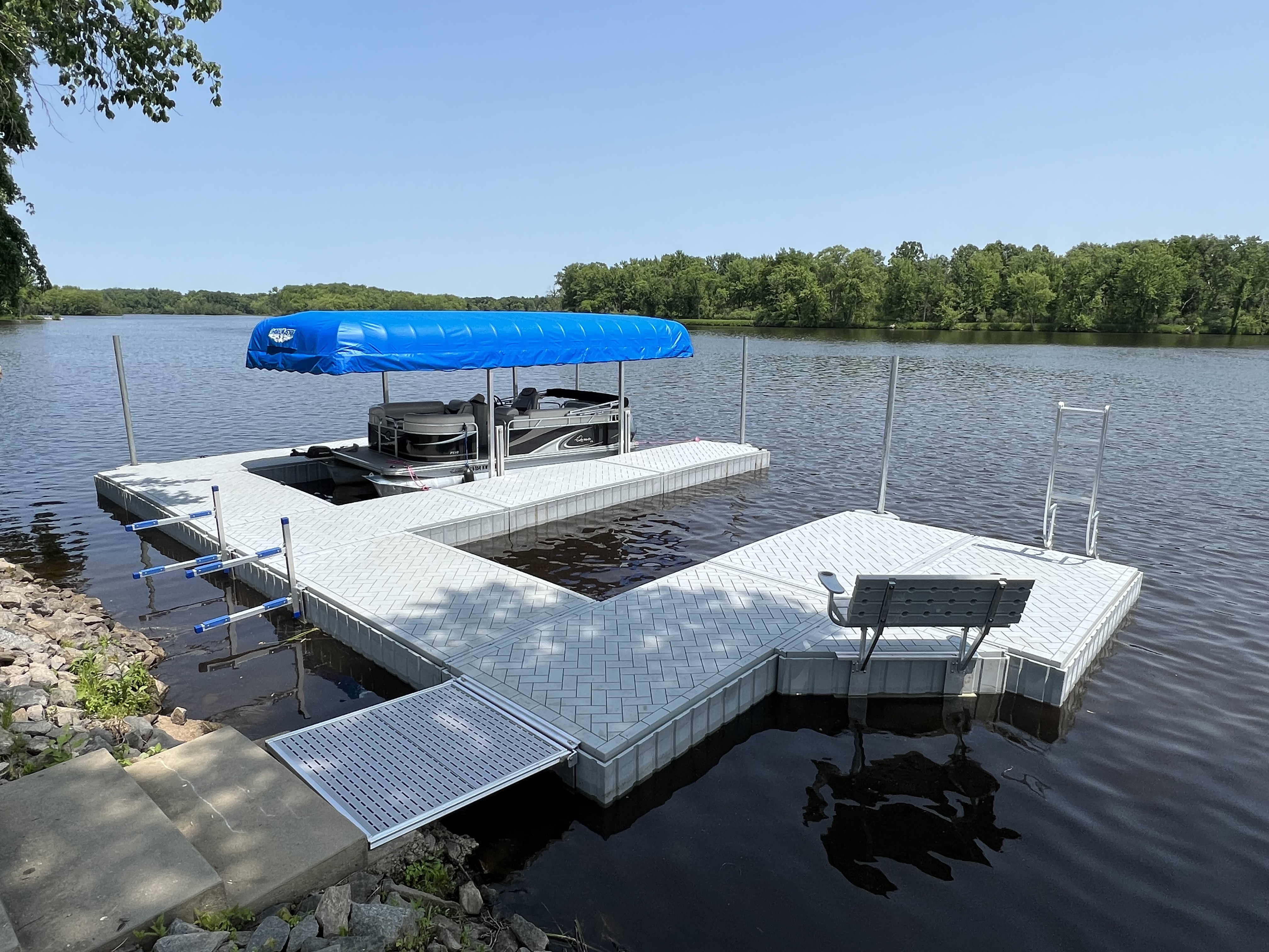 RS4 tan aluminum dock with 6ft sections featuring a pontoon boat under a blue canopy, bench seating, ladder, and lakefront access ramp