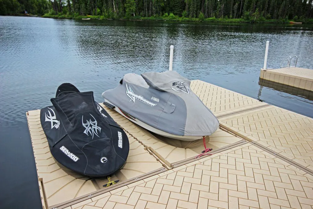 Personal watercraft covered and secured on a floating lake dock